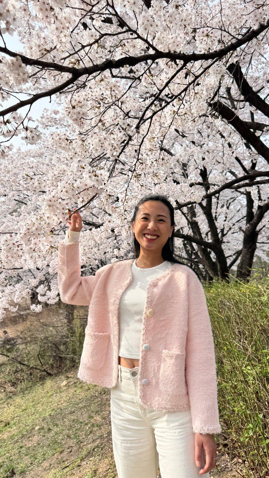Delia smiling under cherry blossoms